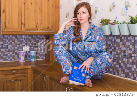 Young red-haired woman relaxing at home with books. Quarantine, isolation, coronavirus pandemic world. Stay at home. Young red-haired woman relaxing at home with books. Quarantine, isolation, coronavirus pandemic world. Stay at home. 65813875