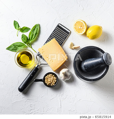 Green basil pesto - italian recipe ingredients Fresh basil, tomatoes, salt and mixe pepper on white concrete Cooking or food background. Top view or flat lay Green basil pesto - italian recipe ingredients Fresh basil, tomatoes, salt and mixe pepper on white concrete Cooking or food background. Top view or flat lay 65815914