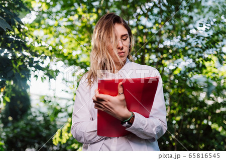 Young female agricultural engineer working in greenhouse. 65816545