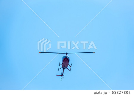 A small helicopter flies in a clear blue sky. A small helicopter flies in a clear blue sky. 65827802