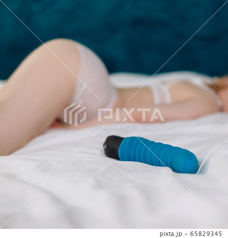 View on blue rubber sexy toy with sexy blonde woman in white lingerie. 65829345