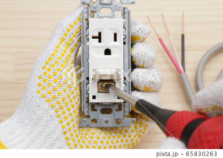 電気工事 コンセントにアース線接続作業の写真素材