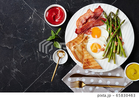 fried egg, crispy bacon, toasted bread, asparagus fried egg, crispy bacon, toasted bread, asparagus 65830463