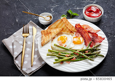 fried eggs, crispy bacon, toast, asparagus spears fried eggs, crispy bacon, toast, asparagus spears 65830465