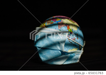Earth globe with geografical names in Ukrainian cyrillic letters on it dressed in a surgical mask on black background. Coronavirus epidemic in world, pandemic danger, global quarantine concept 65831763