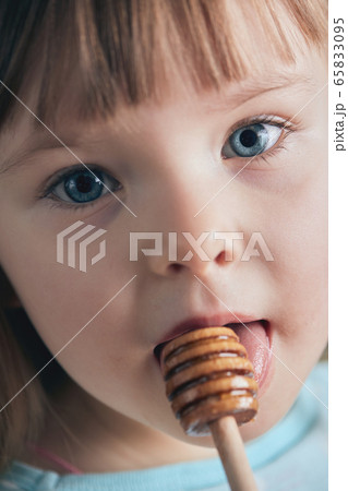 The child eats honey. Selective focus.  65833095