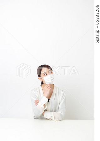 マスクをして座りながら腕を組んでいる女性 マスクをして座りながら腕を組んでいる女性 65833206