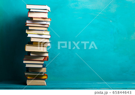 Composition with vintage old hardback books, diary, fanned pages on wooden deck table and abstract background. Books stacking. Back to school. Copy Space. Education background. 65844643