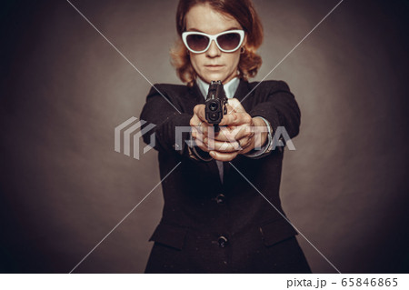 aiming weapon woman in suit. dangerous situation, endangerment aiming weapon woman in suit. dangerous situation, endangerment 65846865