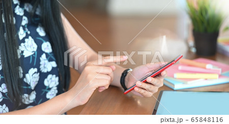 Cropped image of beautiful woman hands holding and using a smartphone. 65848116