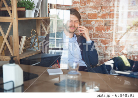 Young man, manager, team led return to work in his office after quarantine, feels happy and inspired Young man, manager, team led return to work in his office after quarantine, feels happy and inspired 65848593