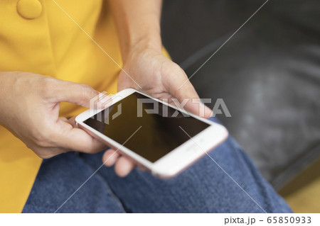 This image is a picture of a hands playing a smart phone. 65850933