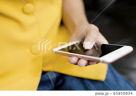This image is a picture of a hands playing a smart phone. 65850934
