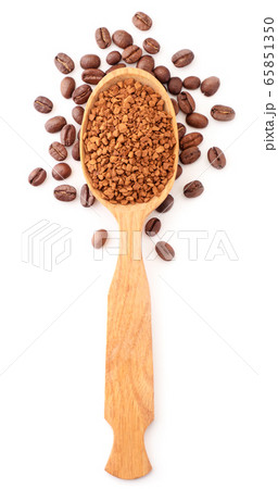 Instant coffee in a wooden spoon, coffee grains 65851350