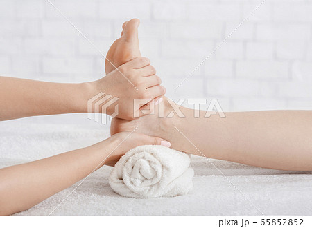 Foot massage in spa salon. Masseur does procedure on table 65852852