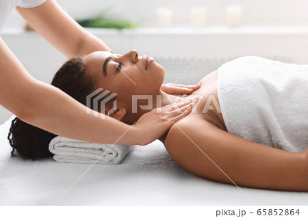 Young black lady getting body massage at spa Young black lady getting body massage at spa 65852864