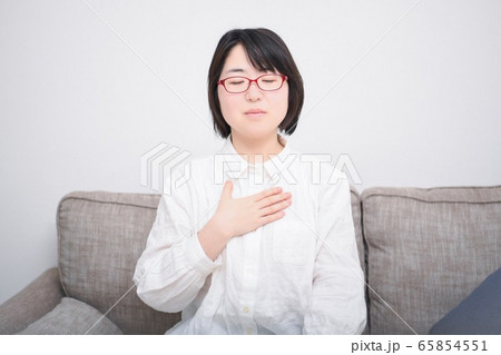 胸に手を当てる女性 65854551