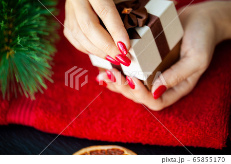 Red Christmas manicure make in beauty studio on Christmas background 65855170