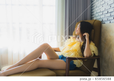 Portrait young asian woman relax happy smile on sofa chair in living room Portrait young asian woman relax happy smile on sofa chair in living room 65856588