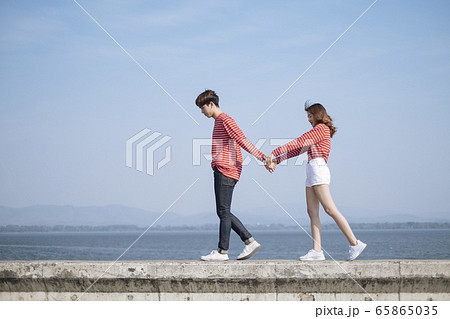 College couple holding their hands walking on the 65865035