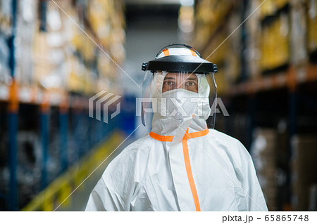 Worker with protective mask and suit in industrial factory, looking at camera. 65865748