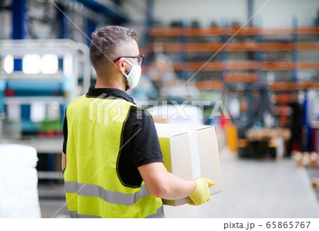 Man worker with protective mask working in industrial factory or warehouse. 65865767