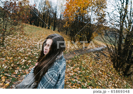 Red-headed freckled girl in autumn yellow park. The first snow, wet rain. 65869348