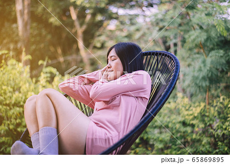 Beautiful young asian woman lying down with hands on her head and sleeping on modern chair at outdooe,Relaxing time,Happy and smiling Beautiful young asian woman lying down with hands on her head and sleeping on modern chair at outdooe,Relaxing time,Happy and smiling 65869895