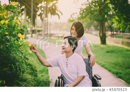 Senior care insurance concept,Caregiver take care to elderly asian woman sitting on wheelchair at outdoor Senior care insurance concept,Caregiver take care to elderly asian woman sitting on wheelchair at outdoor 65870523