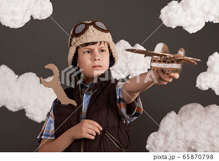 a boy plays with a cardboard airplane and wrench a boy plays with a cardboard airplane and wrench 65870798