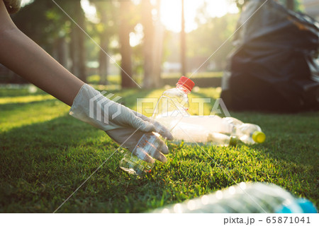 Volunteer woman hands keep plastic bottle on green grass,Good conscious mind,Dispose recycle and waste management concept Volunteer woman hands keep plastic bottle on green grass,Good conscious mind,Dispose recycle and waste management concept 65871041