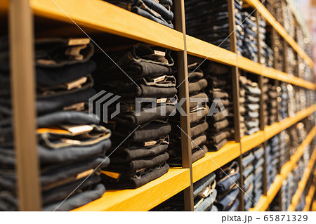 shelf with denim pants for sale in a boutique 65871329