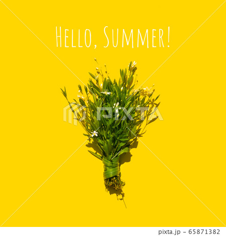 Delicate bouquet of little flowers on a yellow background. Flat lay summer concept 65871382