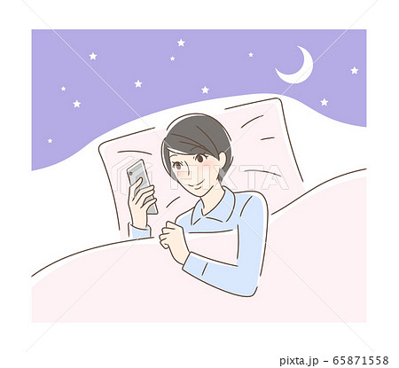 布団の中でスマホを見る笑顔の女性 65871558