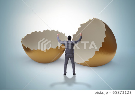 Businessman breaking out of golden egg 65873123