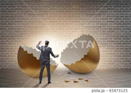 Businessman breaking out of golden egg 65873125