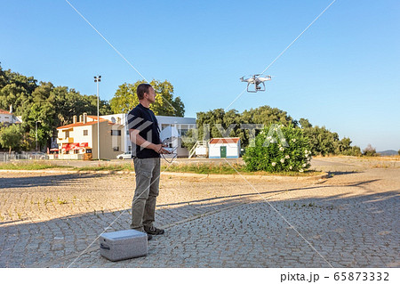 Man, an engineer pilot, prepares air device for take-off, for testing and filming a vileo and photograph. By controlling the remote. 65873332