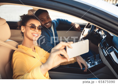 Joyful Spouses Making Selfie Sitting In Car Traveling On Vacation Joyful Spouses Making Selfie Sitting In Car Traveling On Vacation 65875090