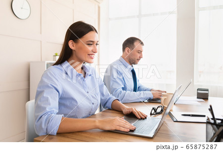 Business Woman And Man Working On Laptop Computers In Office Business Woman And Man Working On Laptop Computers In Office 65875287