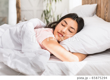 Asian Girl Sleeping Hugging Pillow Resting In Comfortable Bed Indoors 65875294