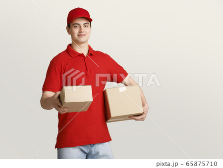 Waiting for parcel. Delivery man in uniform gives parcel at home 65875710