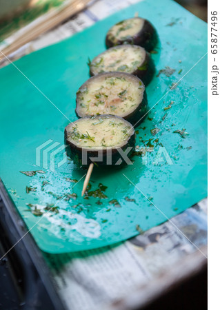 in a bowl, raw, struck eggplant in a marinade with herbs, dill in a rustic natural form. Preparation 65877496