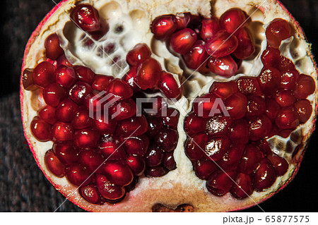 Broken pomegranate fruit on a dark background. close-up. view from above Broken pomegranate fruit on a dark background. close-up. view from above 65877575
