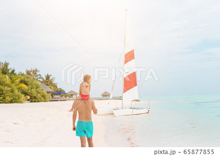 Little girl and happy dad having fun during beach vacation Little girl and happy dad having fun during beach vacation 65877855