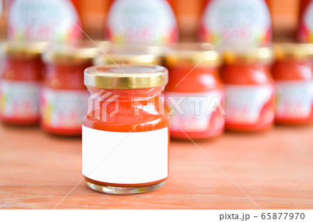 Ketchup in a glass jar and the white paper. Ketchup in a glass jar and the white paper. 65877970