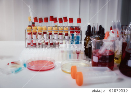 Blood samples in tubes and syringes on work table. 65879559