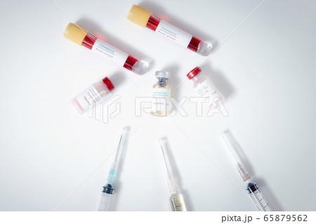 Top view of vaccine, blood samples in tubes and syringes on work table. 65879562