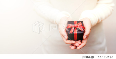 Close up shot of daughter hands holding a small gift Close up shot of daughter hands holding a small gift 65879648