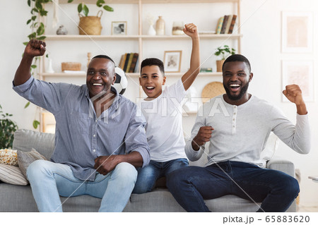 Soccer Fans. African Father, Son And Grandfather Watching Football Game On TV Soccer Fans. African Father, Son And Grandfather Watching Football Game On TV 65883620