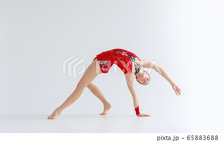 Rhythmic gymnastics practice. Flexible girl doing backbend exercise, isolated on white Rhythmic gymnastics practice. Flexible girl doing backbend exercise, isolated on white 65883688